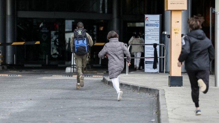 Warga Israel bergegas ke tempat perlindungan setelah sirene peringatan serangan udara berbunyi di Tel Aviv pada Sabtu (28/2) waktu setempat (AFP/JACK GUEZ/detik.com)