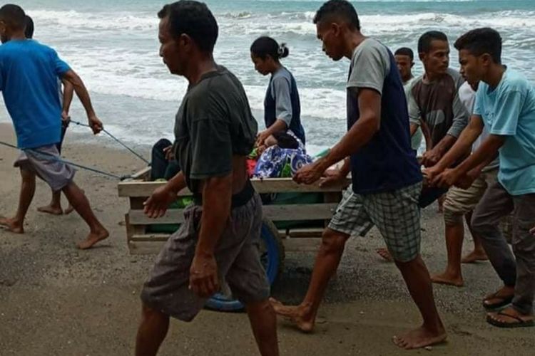 Puluhan warga Desa Desa Misinh, Kecamatan Kilmuri, Kabupaten Seram Bagian Timur membawa seorang warga yang sakit dengan gerobak menuju puskesmas di Kilmuri, Minggu (21/2/2021). Foto : Kompas.com